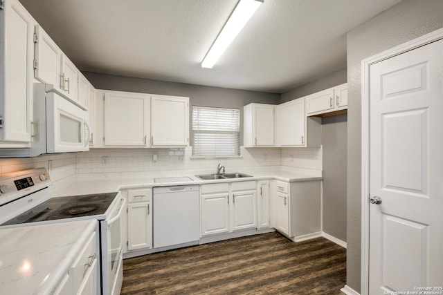 kitchen with white appliances, white cabinetry, and light countertops