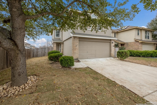 traditional-style home with a garage, brick siding, fence, and driveway