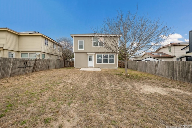 back of property with a yard, a fenced backyard, and a patio