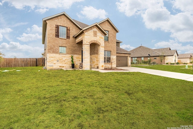 view of front facade with concrete driveway, brick siding, a front yard, and fence