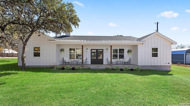 modern farmhouse featuring covered porch, french doors, board and batten siding, and a front yard