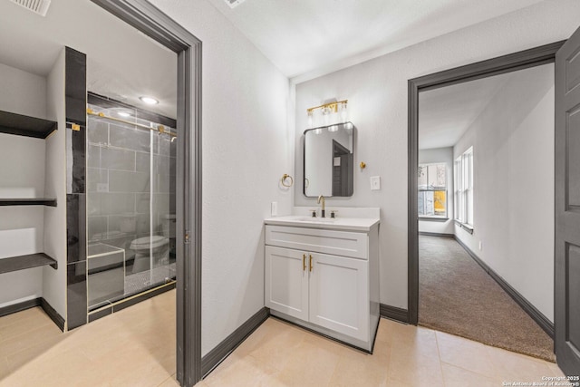 bathroom featuring a stall shower, tile patterned flooring, baseboards, and vanity