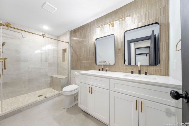 full bathroom featuring tile patterned flooring, tile walls, a sink, and a shower stall