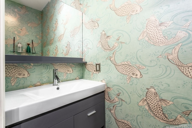 bathroom featuring vanity and wallpapered walls