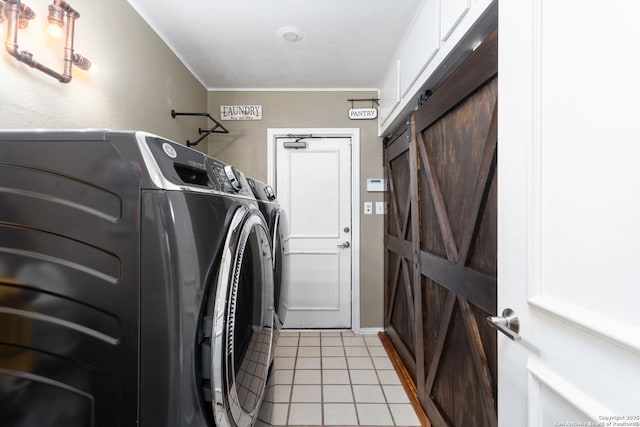 laundry room with crown molding, light tile patterned floors, a barn door, washing machine and dryer, and laundry area