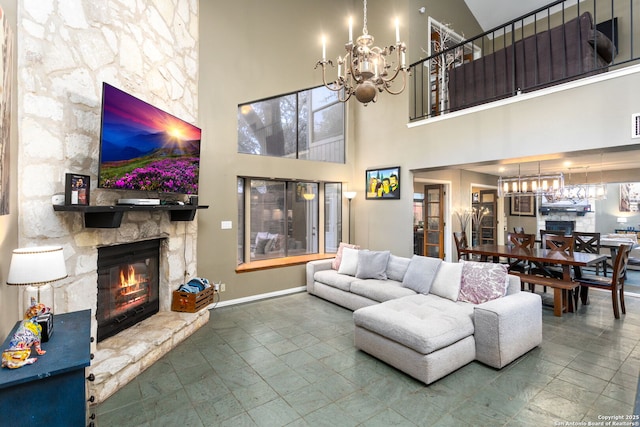 living area featuring a fireplace, baseboards, and a notable chandelier