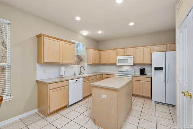 kitchen featuring a center island, light countertops, light brown cabinets, a sink, and white appliances