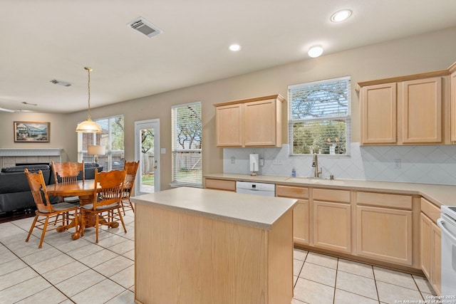 kitchen featuring white appliances, light countertops, a sink, and light brown cabinetry