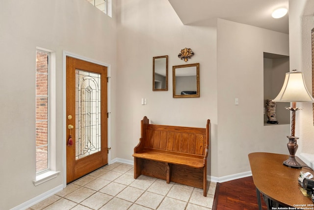 foyer entrance with plenty of natural light, baseboards, and light tile patterned floors