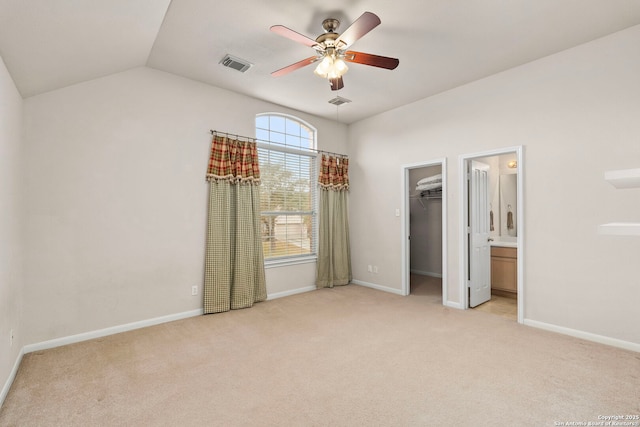 unfurnished bedroom featuring visible vents, light colored carpet, a spacious closet, and baseboards