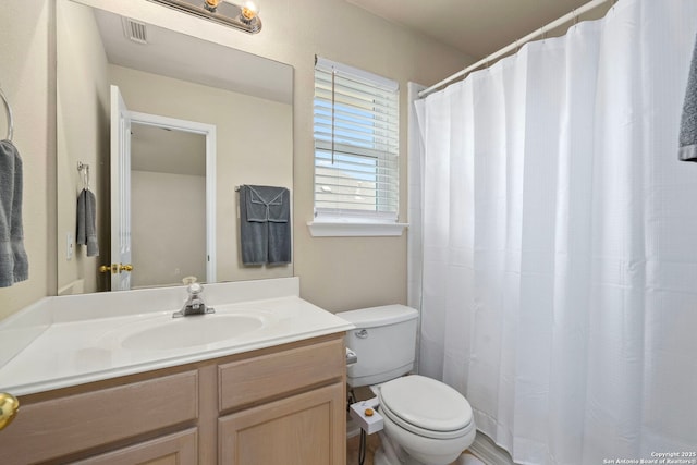 full bath with toilet, vanity, and visible vents