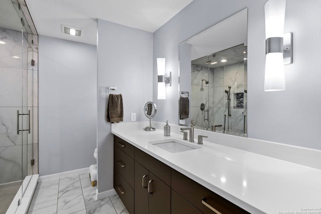 full bath with a marble finish shower, baseboards, visible vents, marble finish floor, and vanity