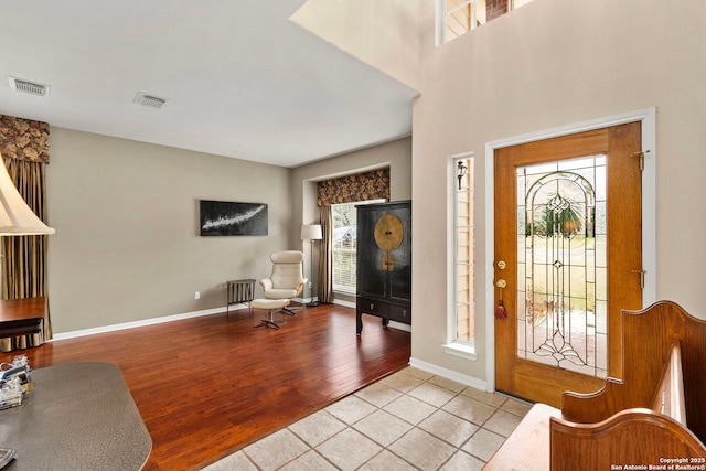 foyer featuring baseboards, visible vents, and light wood finished floors