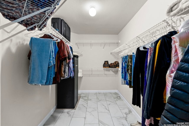 walk in closet with marble finish floor