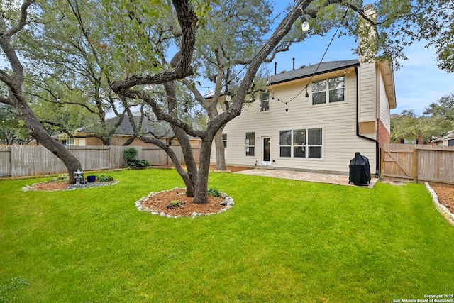 back of house featuring a patio area, a fenced backyard, and a yard