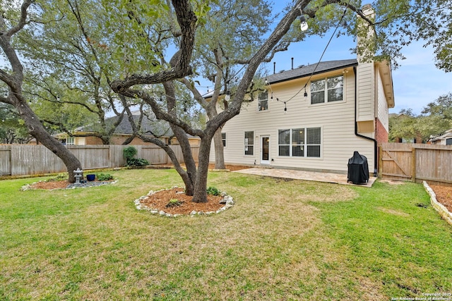 back of property with a patio area, a fenced backyard, and a yard