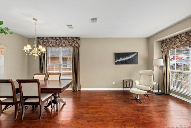 dining area featuring visible vents, dark wood finished floors, a notable chandelier, and baseboards