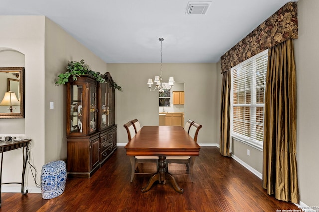 dining space featuring dark wood-type flooring, a wealth of natural light, visible vents, and baseboards