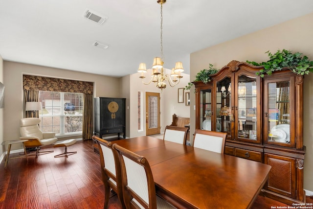 dining room with dark wood-style floors, visible vents, and a chandelier