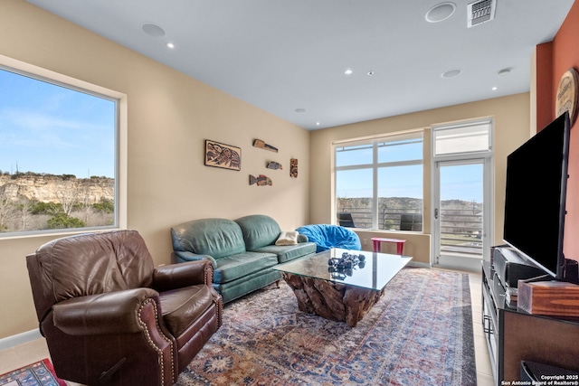 living room featuring a healthy amount of sunlight, light tile patterned floors, visible vents, and recessed lighting