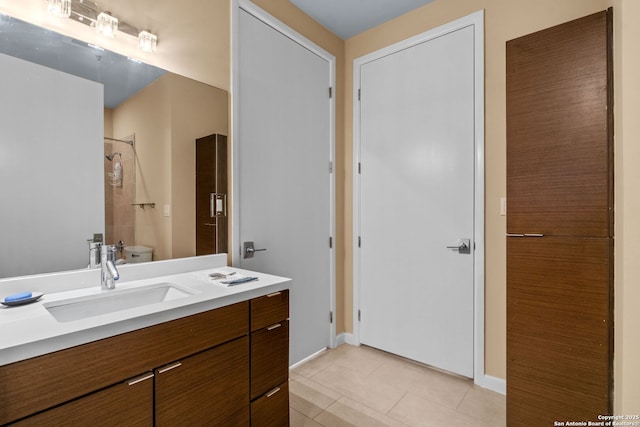 bathroom with toilet, a shower, vanity, and tile patterned floors