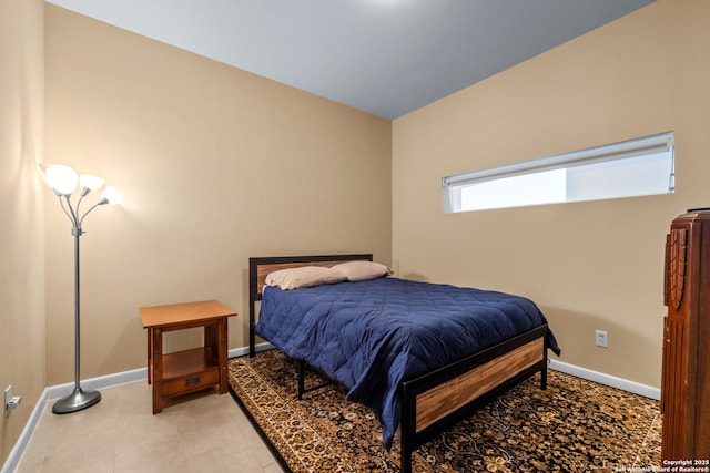 bedroom featuring light tile patterned flooring and baseboards