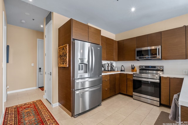 kitchen with visible vents, stainless steel appliances, light countertops, and light tile patterned flooring