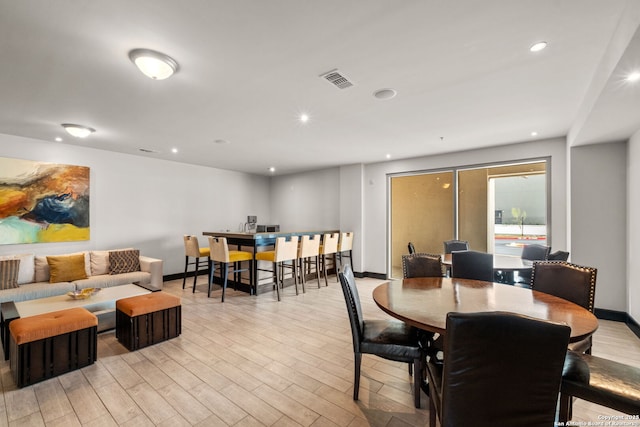 dining room featuring light wood-style flooring, visible vents, baseboards, and recessed lighting