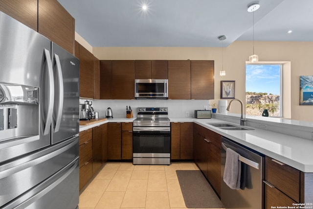 kitchen featuring hanging light fixtures, modern cabinets, appliances with stainless steel finishes, and light countertops