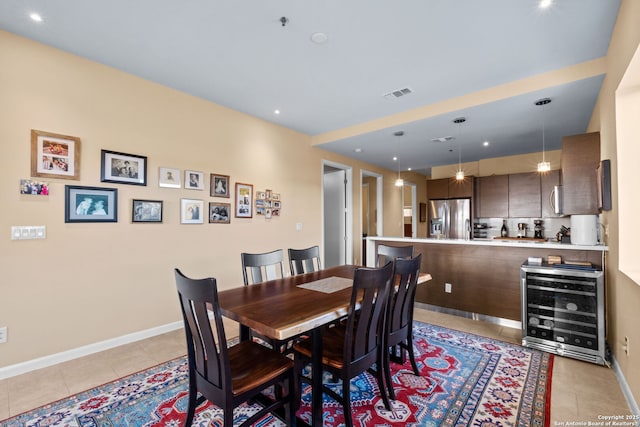 dining space featuring beverage cooler, light tile patterned floors, visible vents, and baseboards