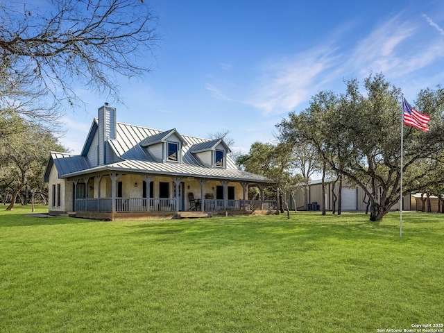 back of property with a chimney, covered porch, a lawn, a standing seam roof, and metal roof