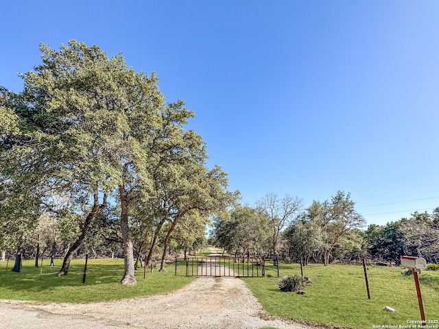 view of property's community featuring a gate and a lawn