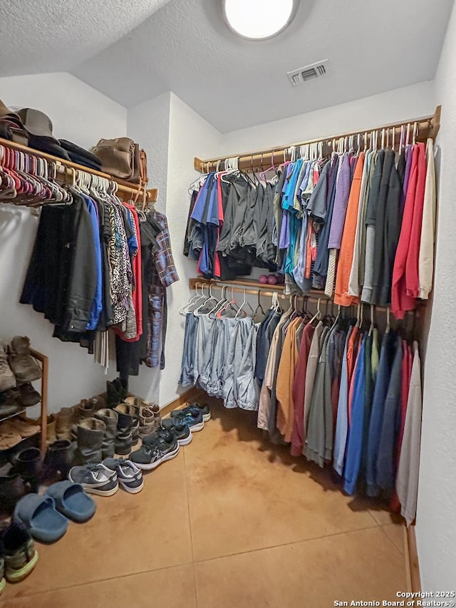 spacious closet with visible vents and vaulted ceiling