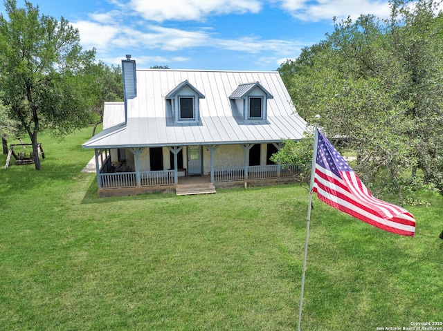 565 Red Bluff Ranch Rd, Pipe Creek, TX 78063 - farmhouse-style home featuring a chimney, covered porch, a front lawn, and metal roof