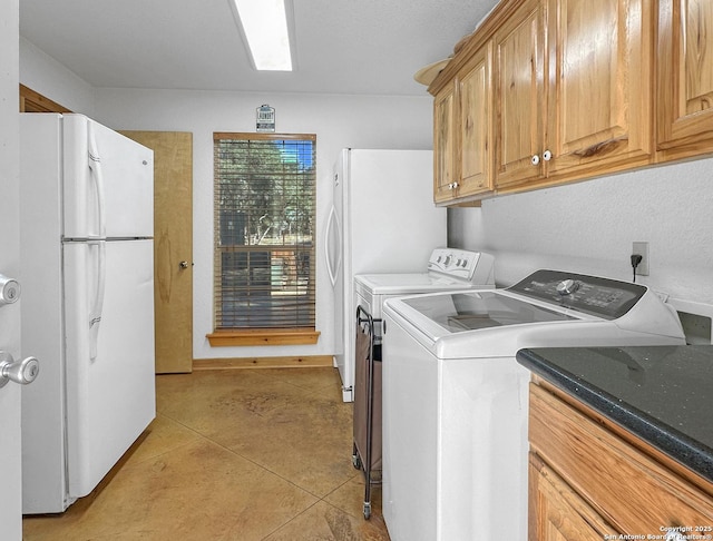 washroom featuring washing machine and dryer, a skylight, and light tile patterned floors