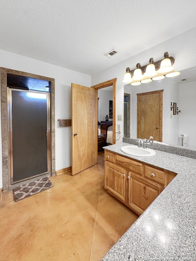 ensuite bathroom with visible vents, concrete floors, a textured ceiling, and ensuite bathroom