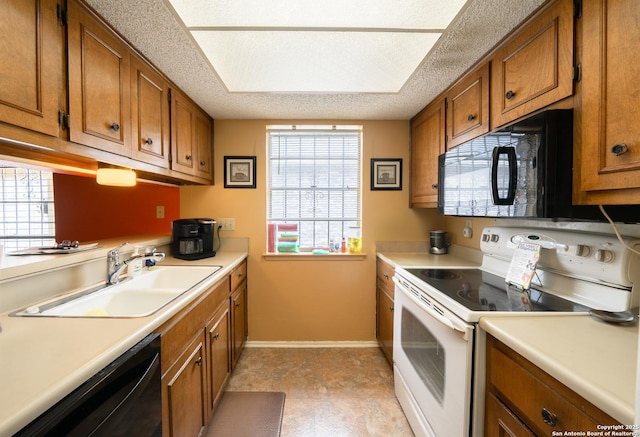 kitchen with black appliances, brown cabinetry, a sink, and light countertops