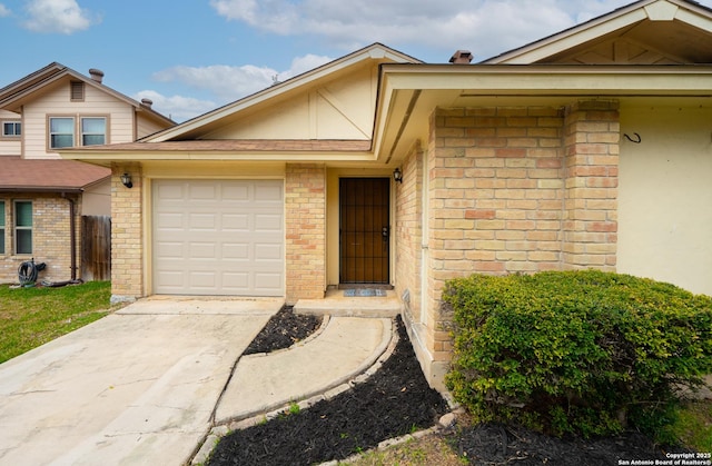 property entrance with a garage, driveway, and brick siding