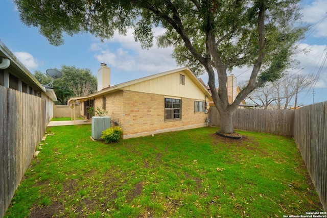 view of yard with a fenced backyard and central AC