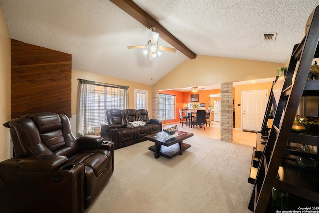 carpeted living room with visible vents, lofted ceiling with beams, ceiling fan, a textured ceiling, and ornate columns