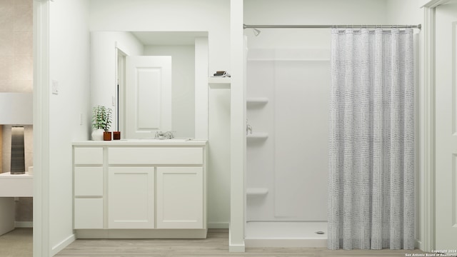 full bath featuring a shower stall, baseboards, wood finished floors, and vanity