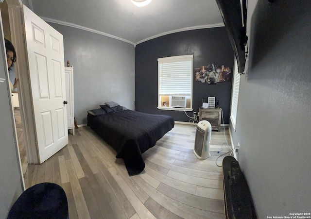 bedroom with baseboards, cooling unit, ornamental molding, and wood finished floors