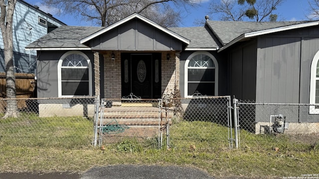 doorway to property featuring brick siding, roof with shingles, a gate, crawl space, and fence