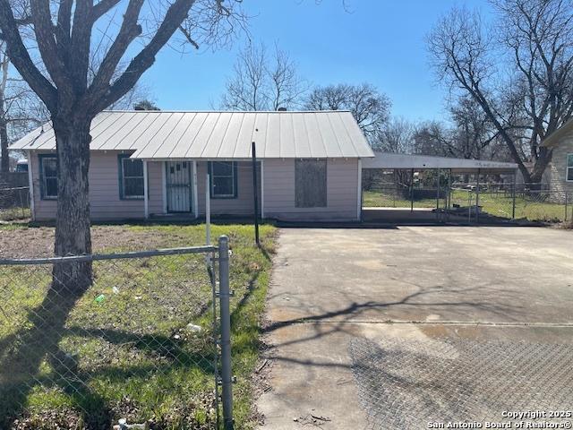 view of front of house with metal roof, fence, driveway, and a standing seam roof