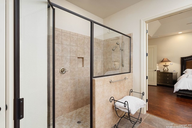 ensuite bathroom featuring ensuite bathroom, a stall shower, and wood finished floors