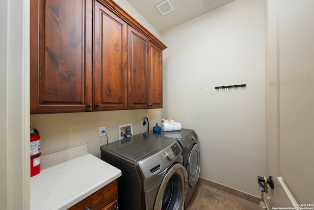 laundry room with washing machine and dryer, cabinet space, visible vents, and baseboards