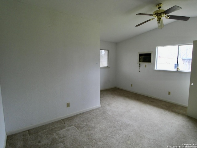 carpeted empty room featuring lofted ceiling, a ceiling fan, and baseboards