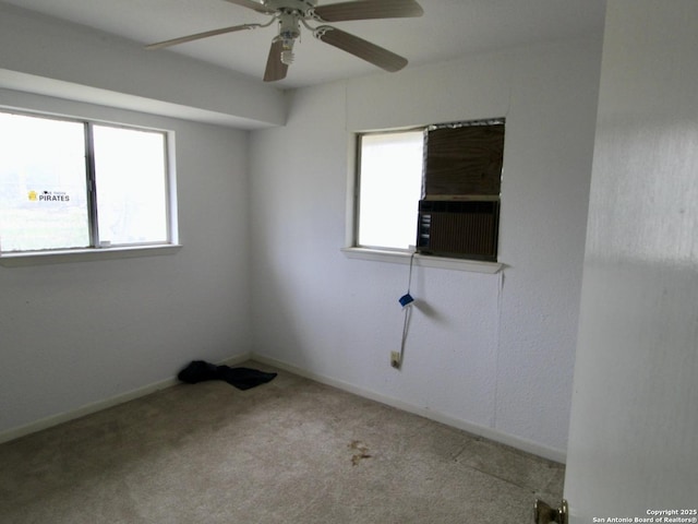 unfurnished room with ceiling fan, baseboards, cooling unit, and light colored carpet