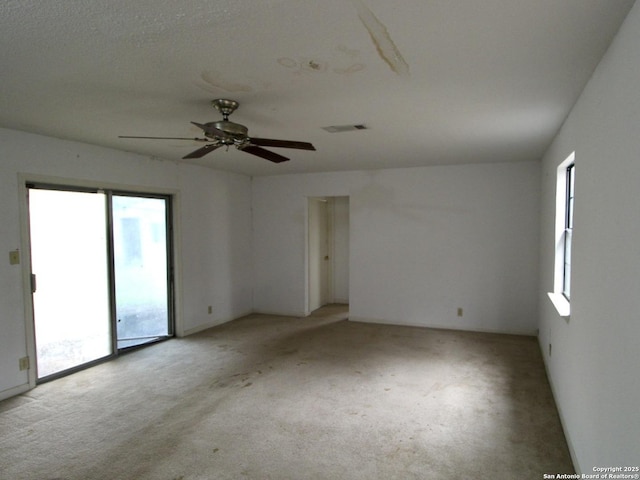 spare room with visible vents and light colored carpet