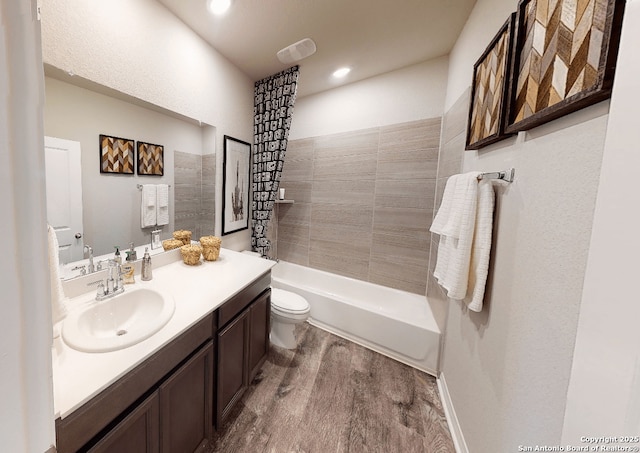 full bath featuring shower / bathtub combination, recessed lighting, toilet, vanity, and wood finished floors